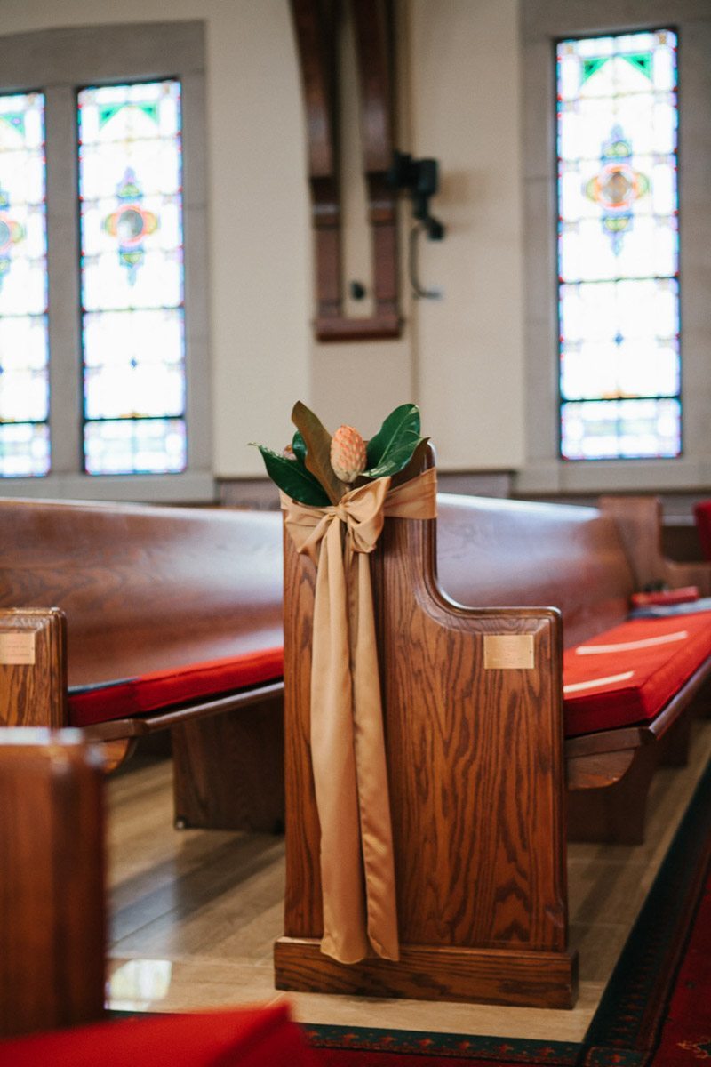 Wooden church pews with foral and ribbon adornments
